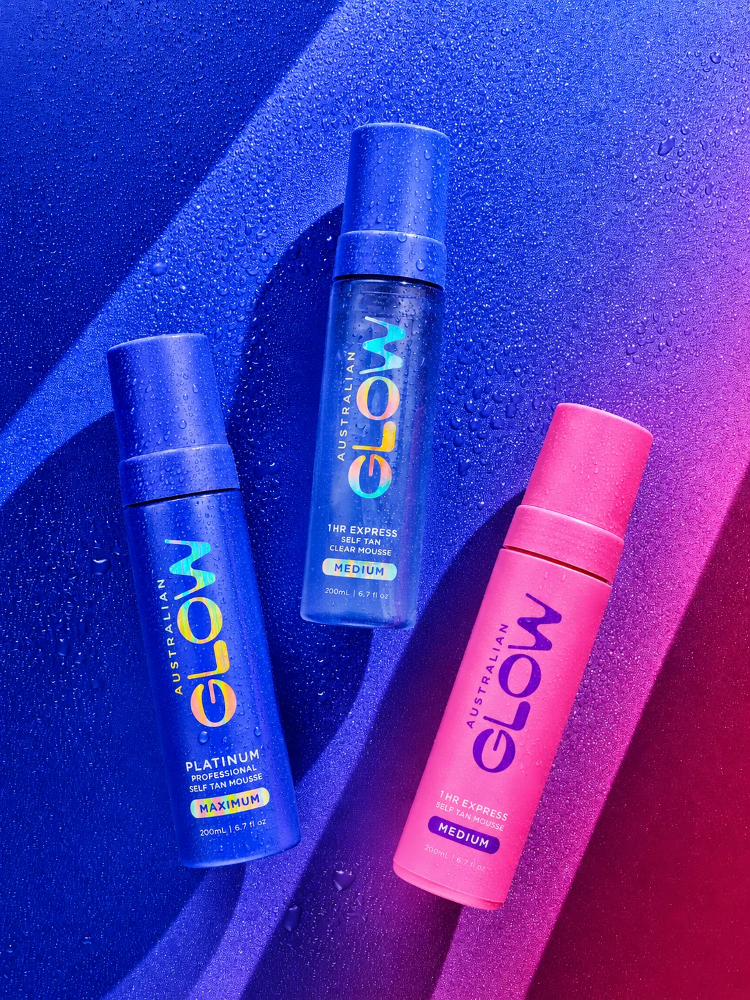 Australian Glow Platinum Professional Self Tan Mousse, three bottles on cobalt-magenta gradient