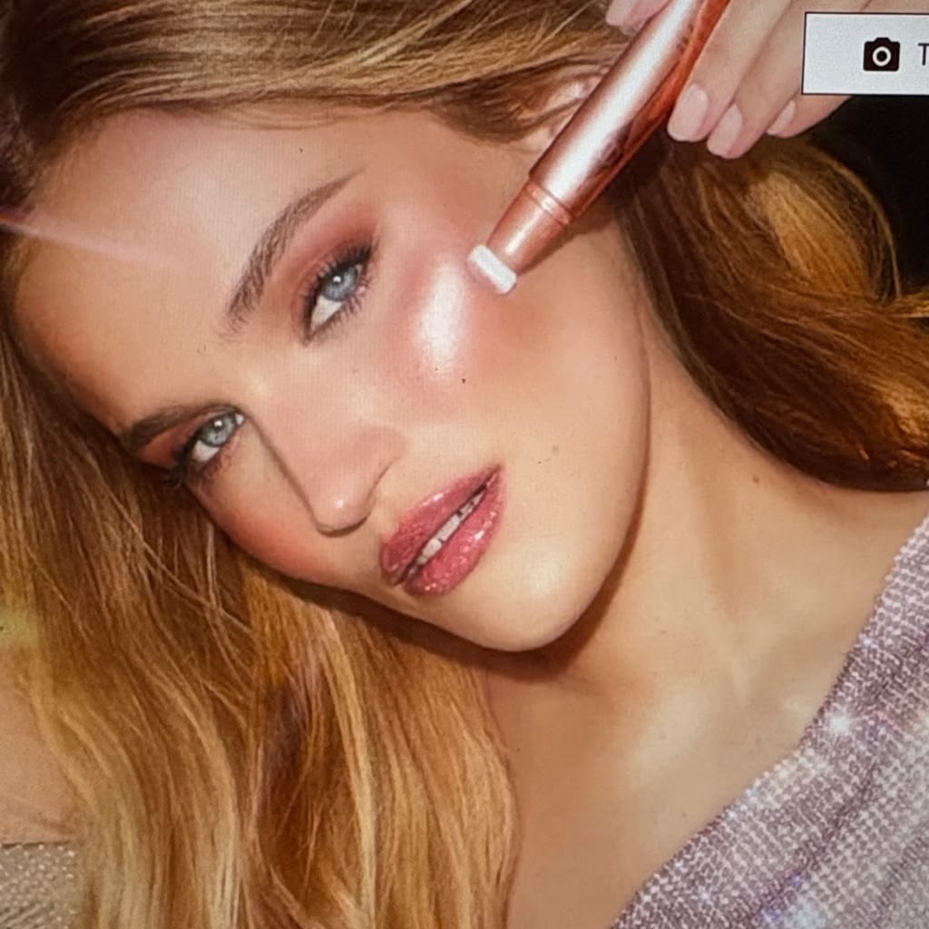 Charlotte Tilbury red-haired model applying Beauty Light Wand