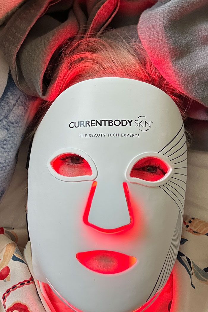 CurrentBody Skin LED Mask mid-treatment, red-light glow during evening session