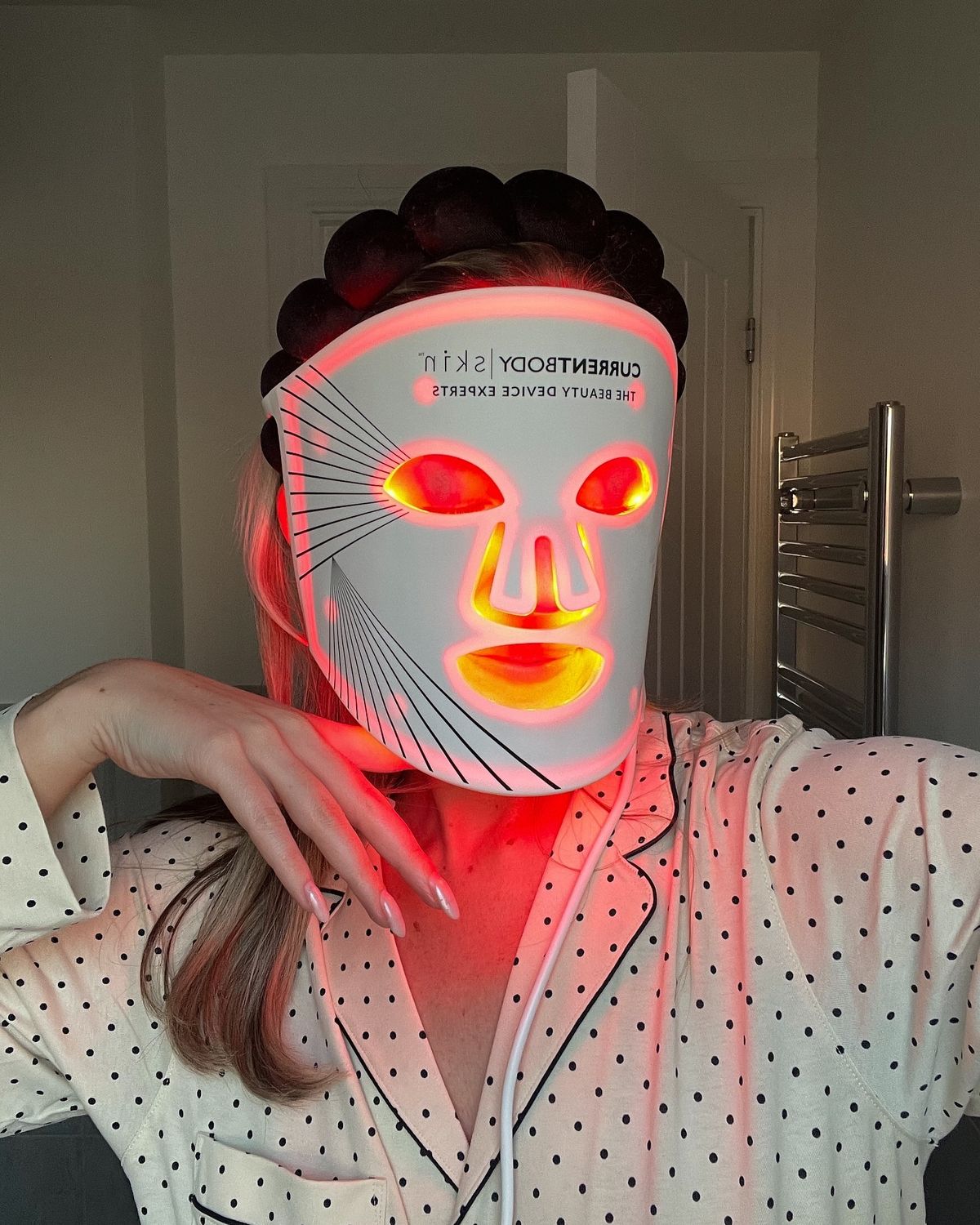 CurrentBody Skin LED Mask flat on a couch, the clinical device at rest in a home
