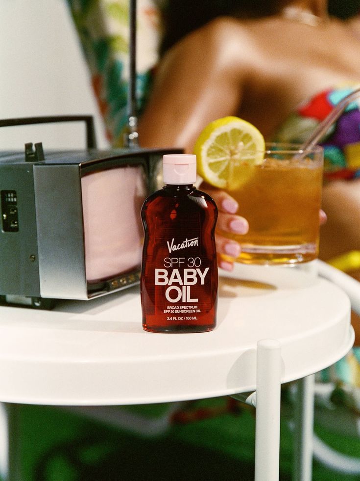 Vacation Baby Oil SPF 30 with retro TV and citrus drink, campaign still