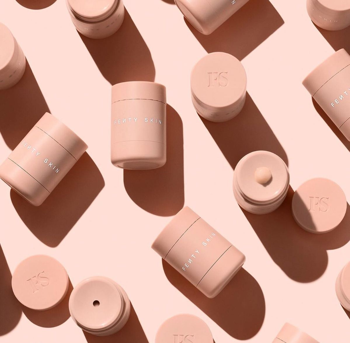 Fenty Skin pink jars in floating composition, campaign still from the Skin extension