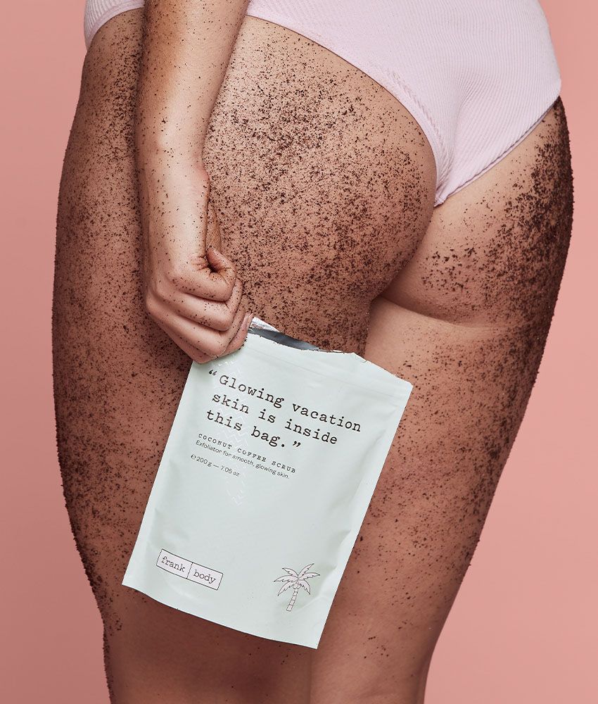 Frank Body Original Coffee Scrub held to a model's thigh, Melbourne body-care editorial
