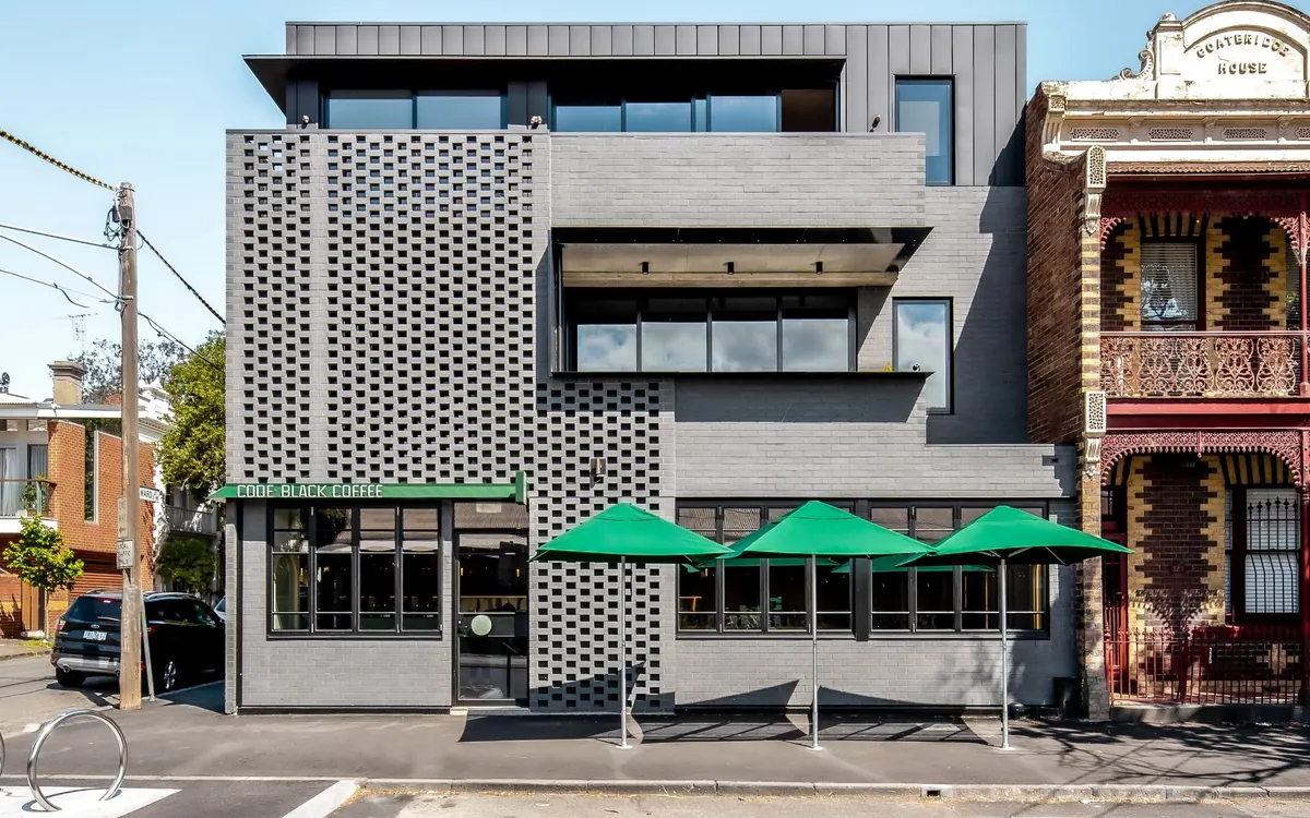 Street front with green café umbrellas at ground level