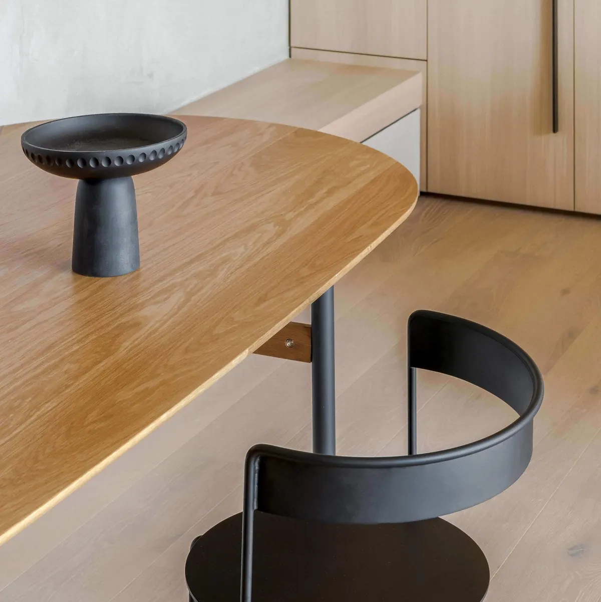 Detail of an oak bench and a black chair